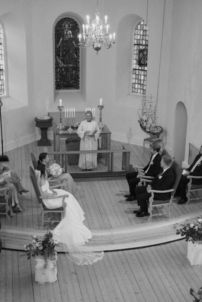 Bryllupsseremoni i kirke med brudepar og gjester, perfekt for et eventyrlig bryllup ved Hvaler.