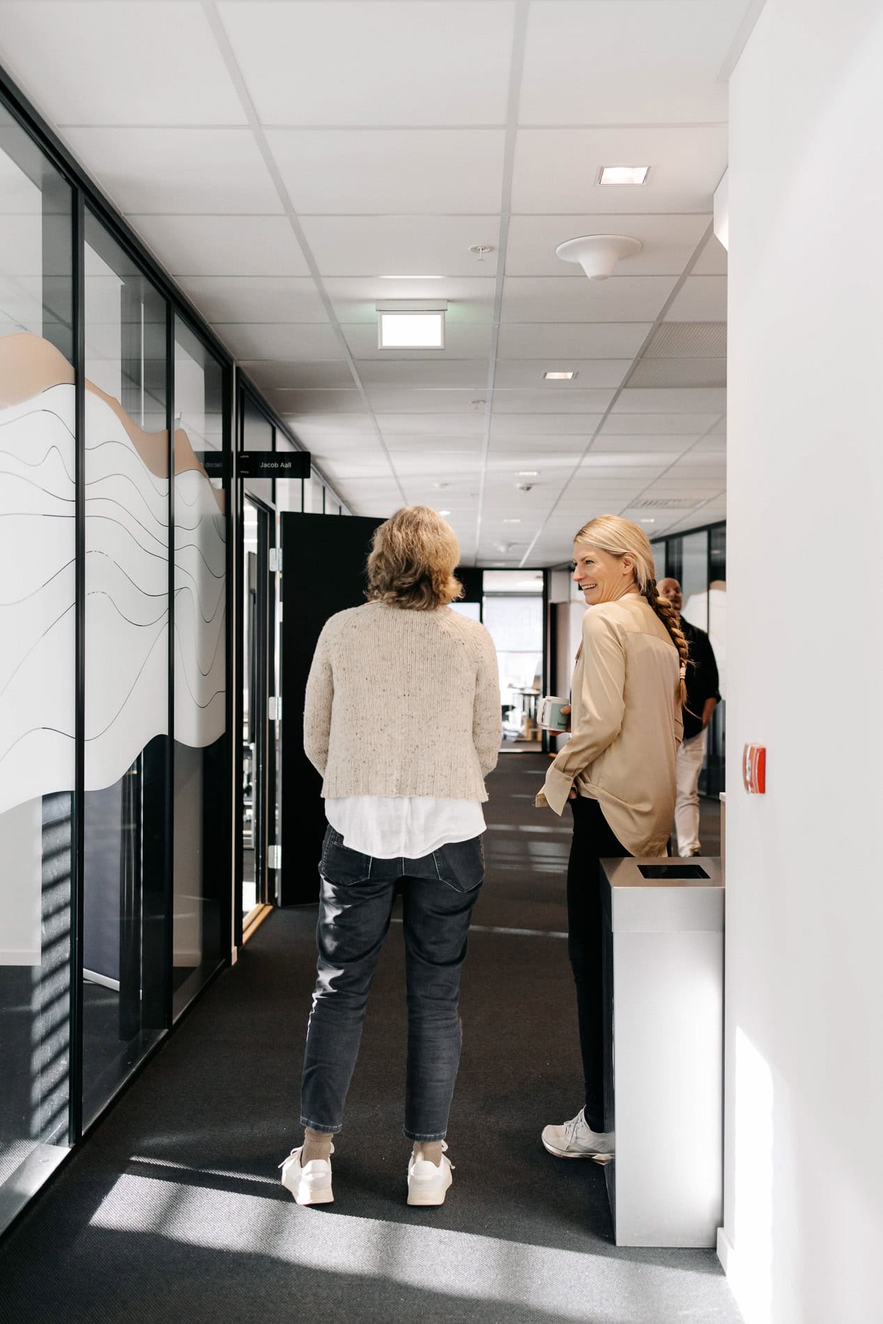 Dame og kvinne i samtale på kontor.