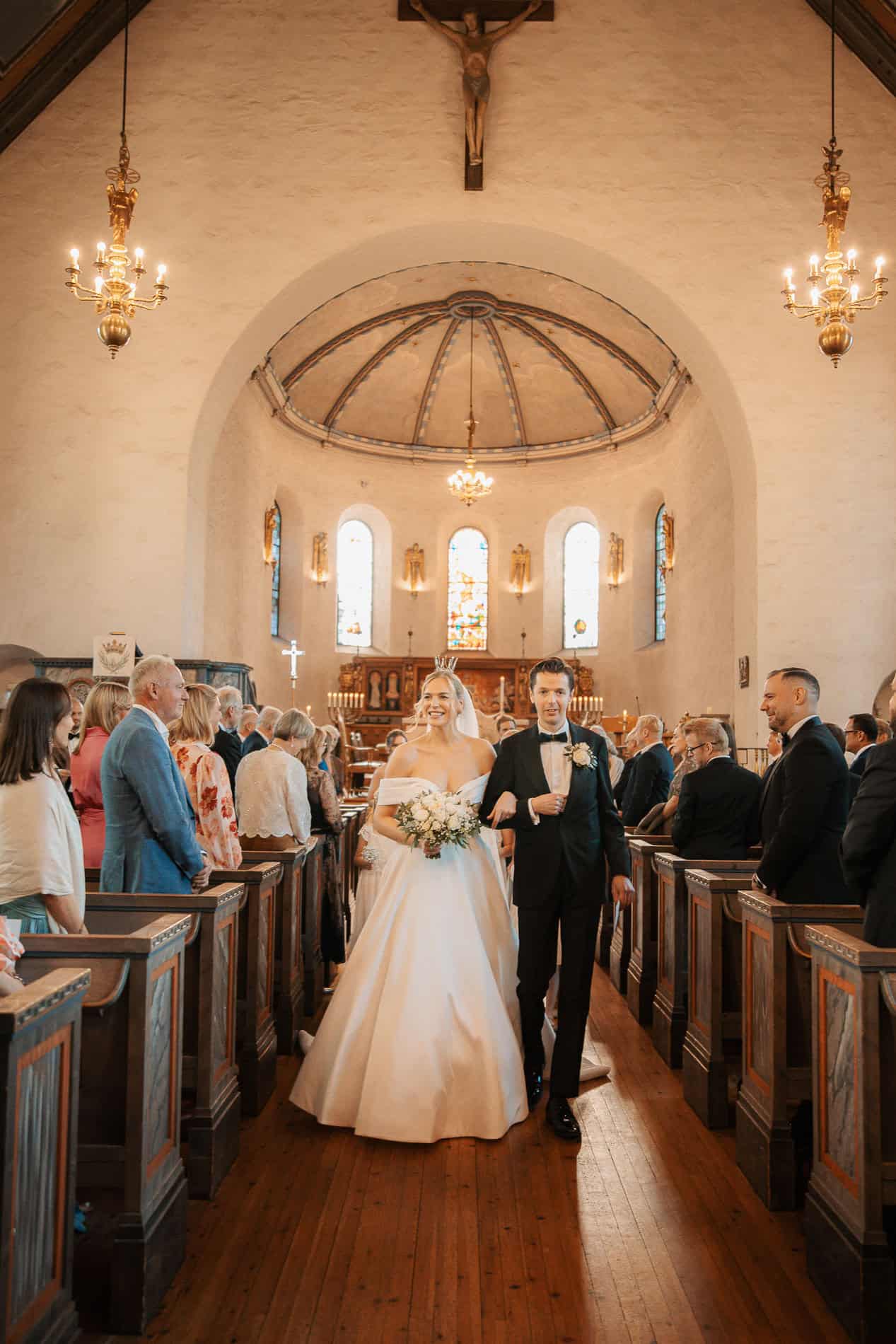 Bryllupsfoto av brudepar i kirken under vielsen.