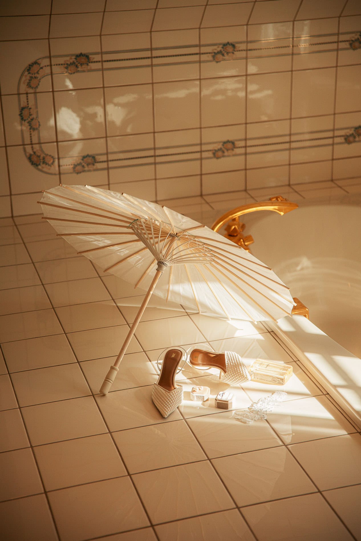 Badeparaply og badekåpe i et lyst badekarrom med fliser.