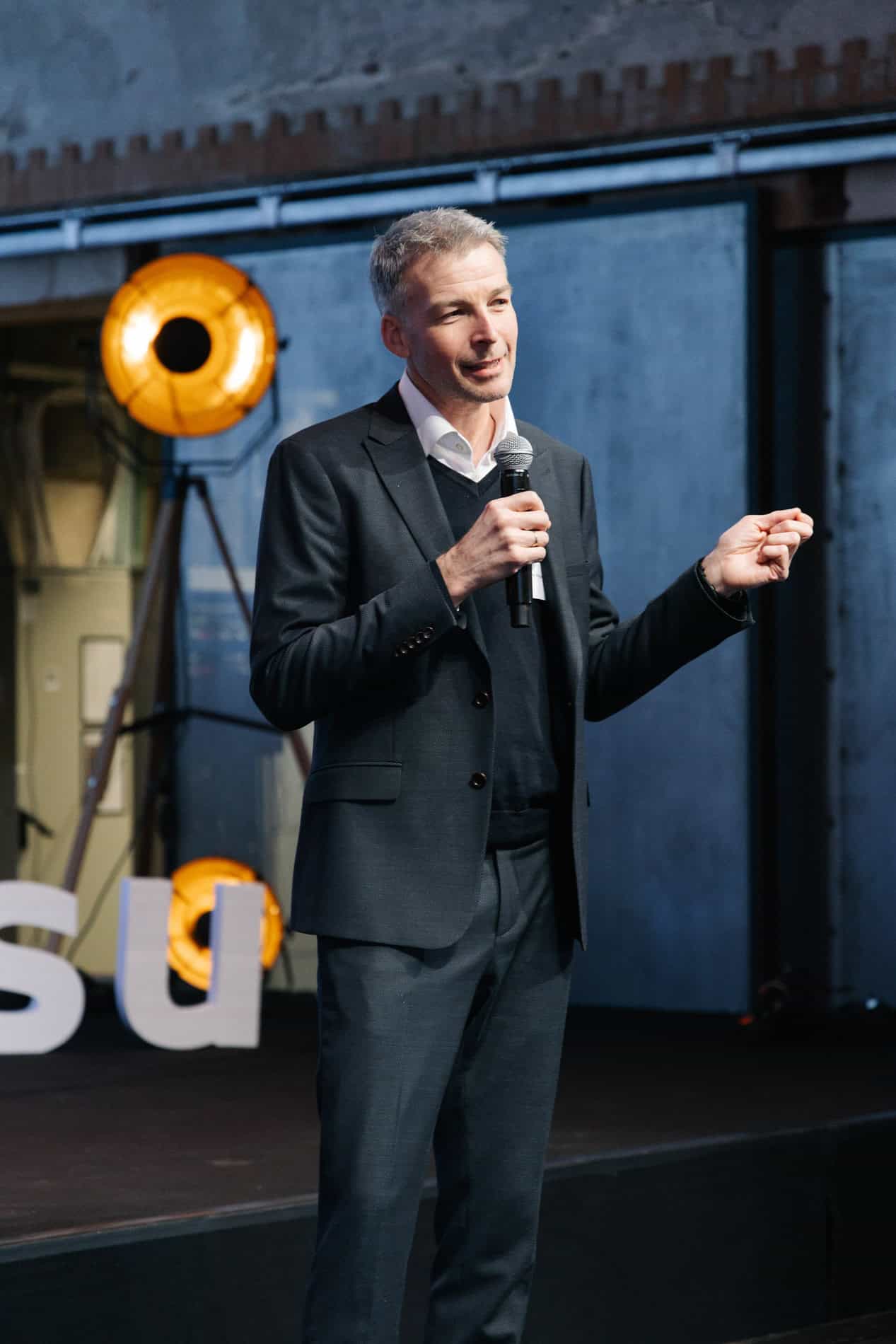 Taler på scenen under bedriftsarrangement, fotograf Heidi Henriksen.
