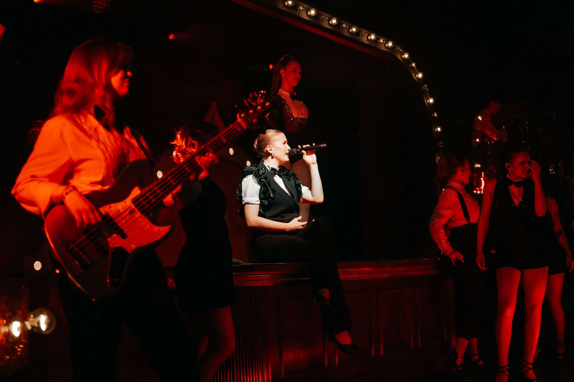 Kunstnere på scenen under en liveopptreden, med fokus på musikk og sceneliv.