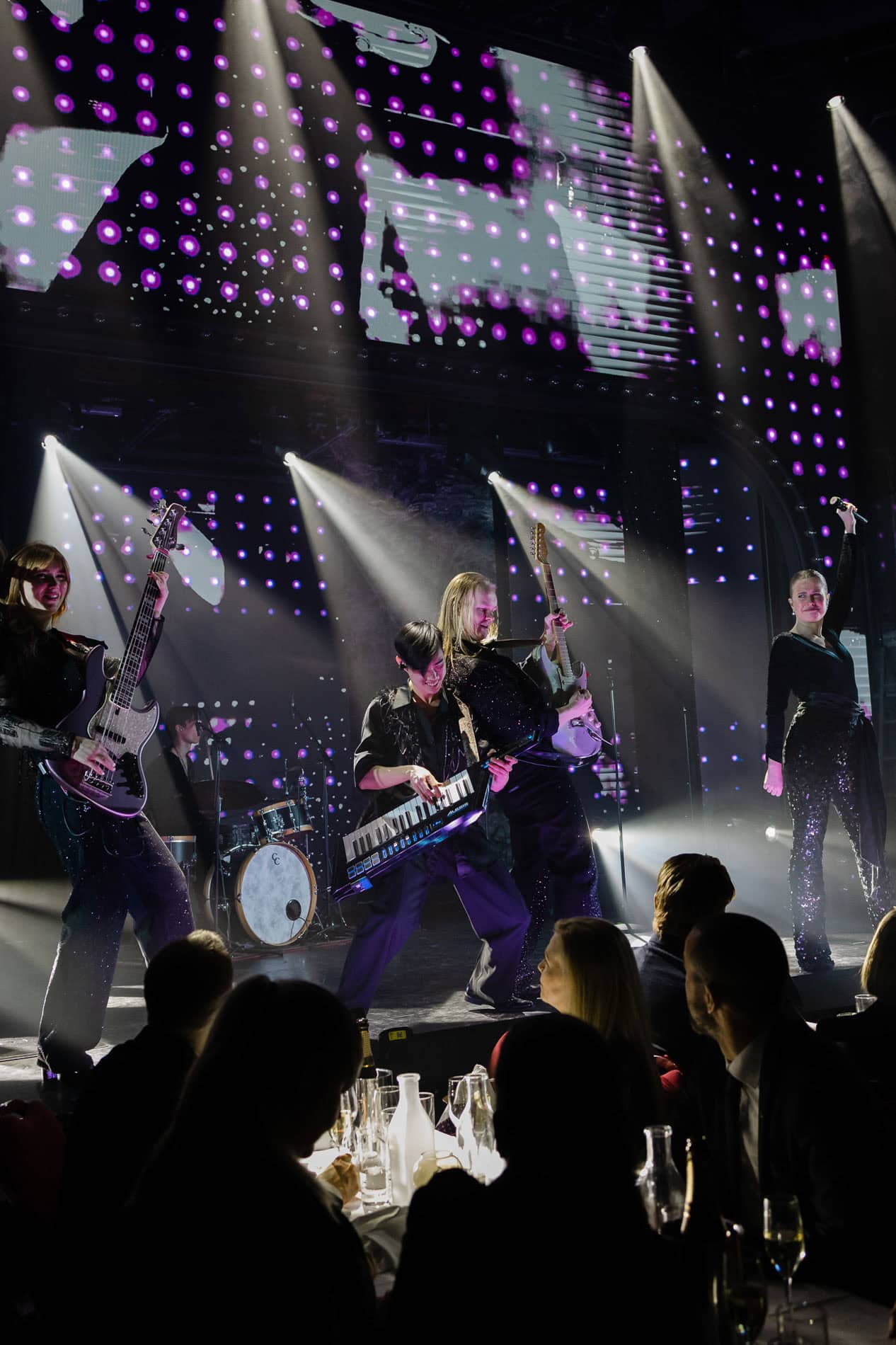 Live band opptreden under bedriftsfoto arrangement med lys og scenelys.