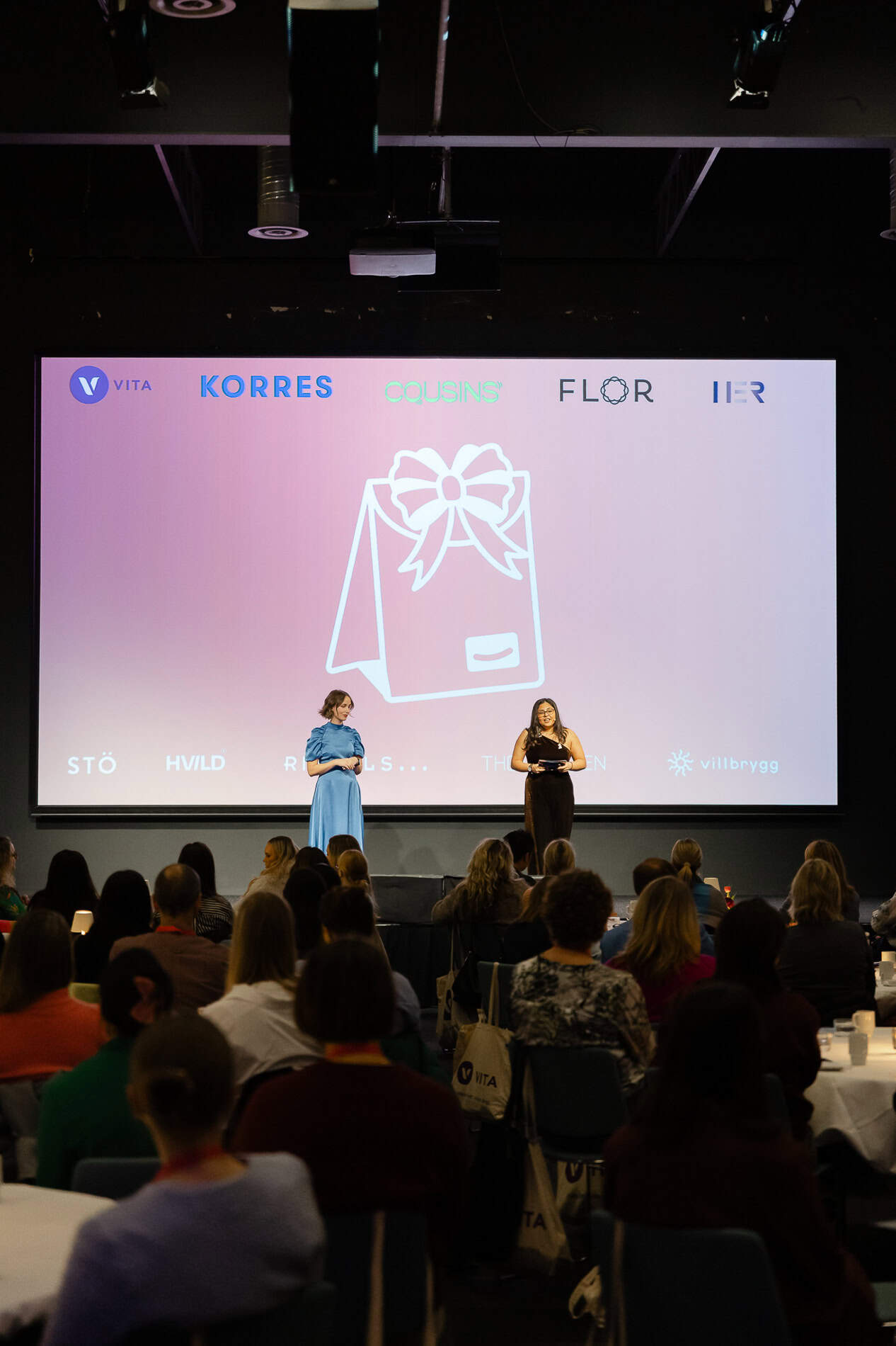 Heidi Henriksen fotografi under konferanse med publikum og stor skjerm.