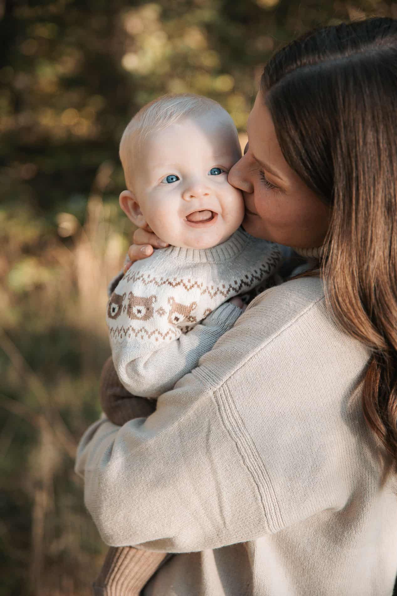 Familieportrett av mor og baby i utendørs natur, fotograf Heidi Henriksen.