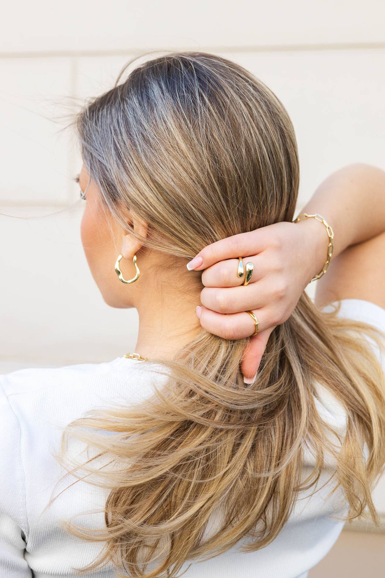 Nærbilde av en kvinne med langt, blond hår og gullsmykker, tatt av Heidi Henriksen.