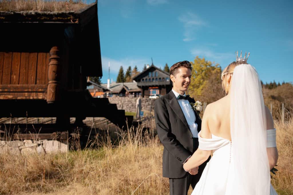 Bryllupsfoto av et par i Oslo, med vakker natur og tradisjonell kysthytte i bakgrunnen.