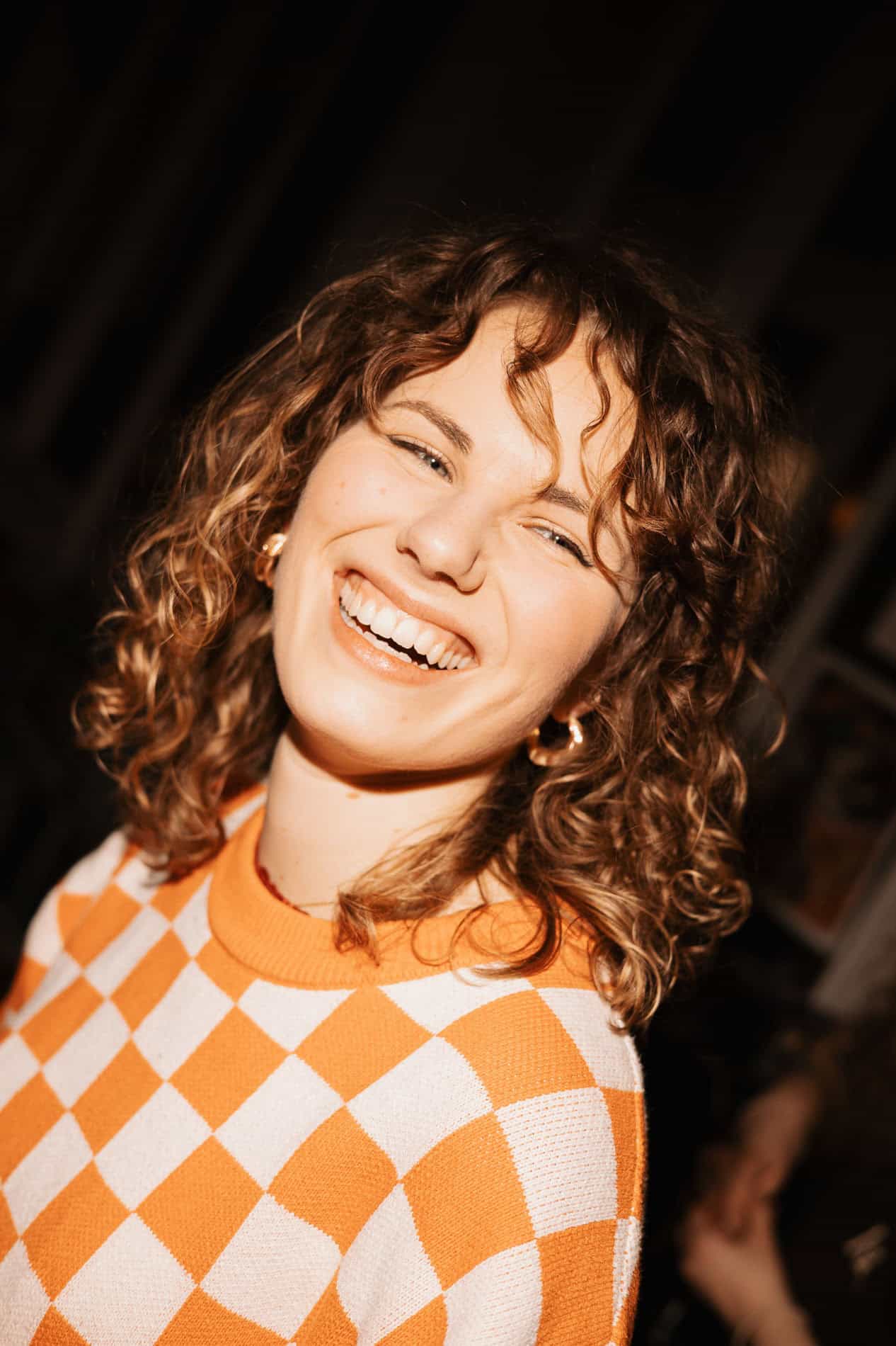 Kvinne smilende i studio for bedriftsfoto, profesjonell portrettfotografering.