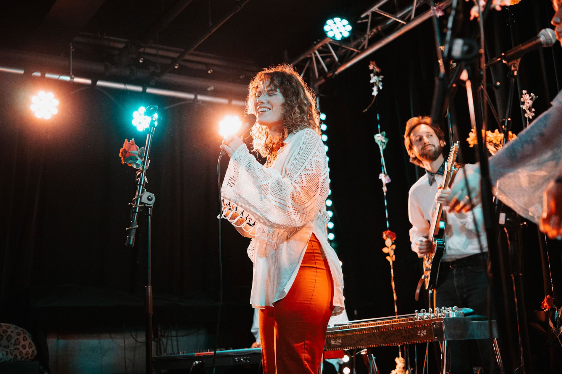 Kunstner på scenen med mikrofon og musikkinstrumenter under bedriftsfoto, levende opptreden i studio.