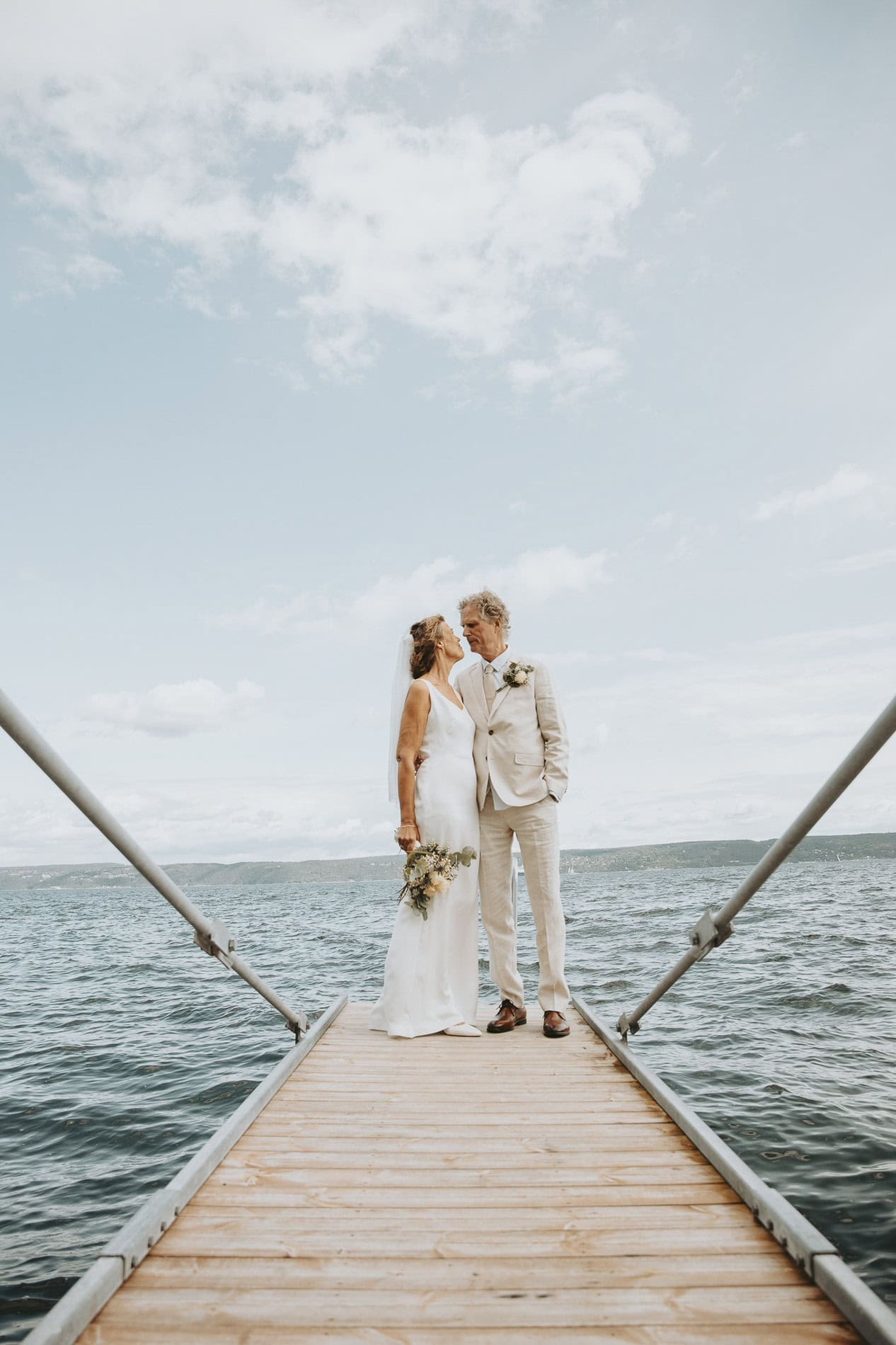 Bryllupsfotograf Heidi Henriksen fanger romantisk øyeblikk mellom brudepar på brygge i Oslo.