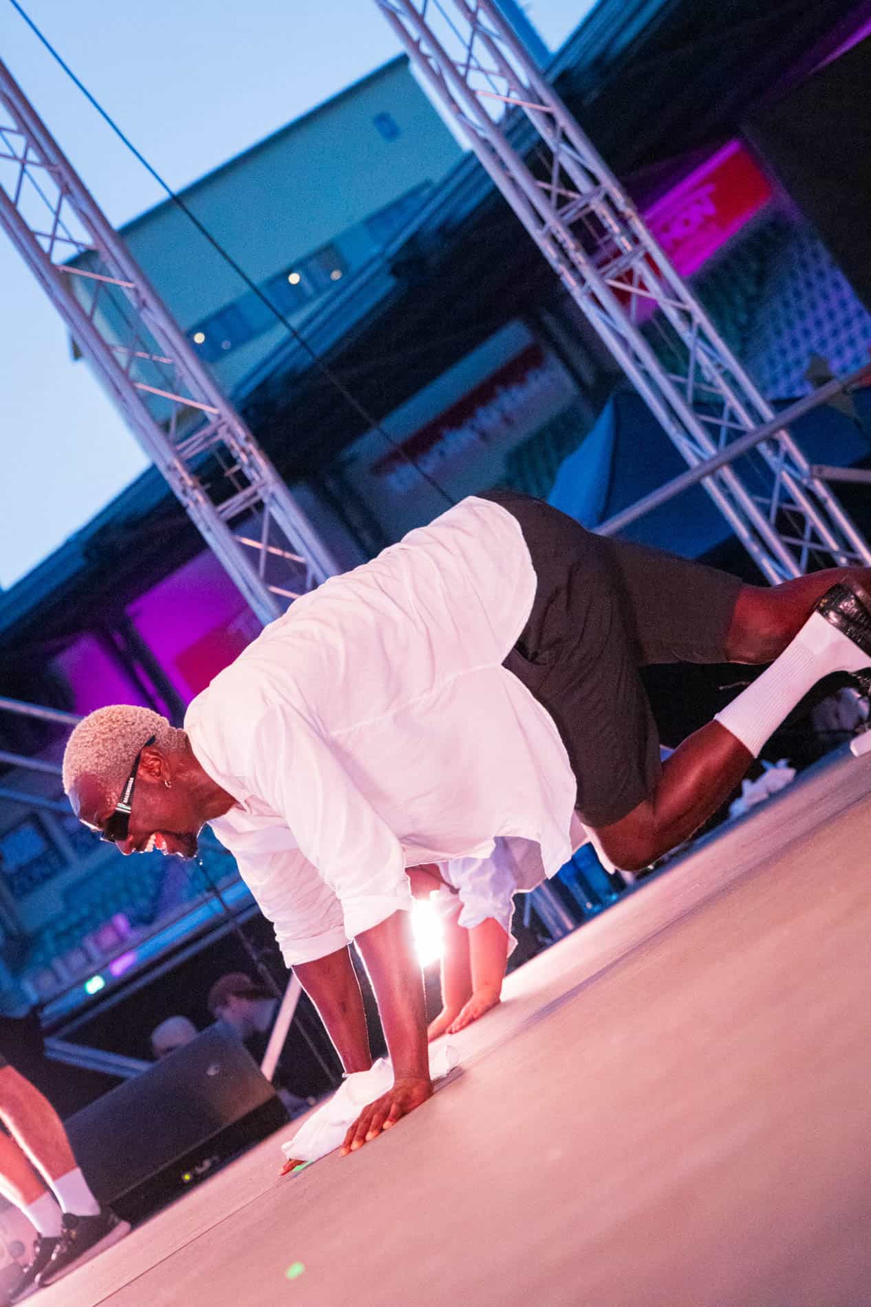 Modell i bedriftssammenheng som gjør yoga på scenen.