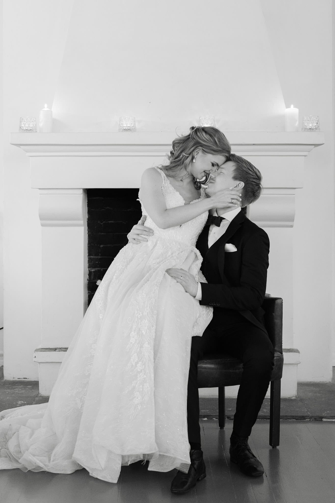 Bryllupsfoto av brudepar foran peis, romantisk og elegant. Fotograf Heidi Henriksen tilbyr profesjon.