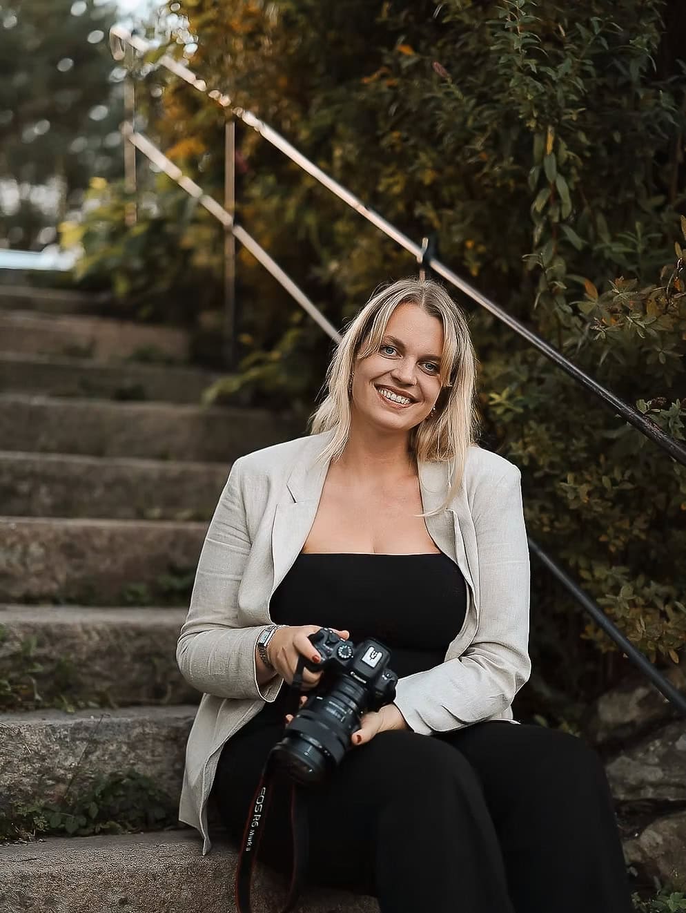 Heidi Henriksen med kamera i utendørs omgivelser.
