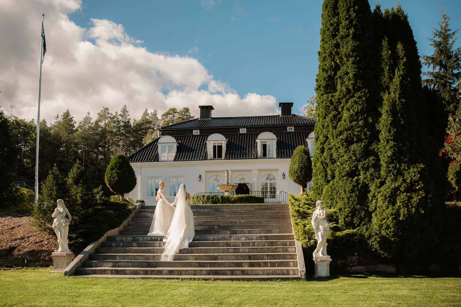 Bryllupsfoto av brudepar på trapp foran elegant villa, fotograf Heidi Henriksen.