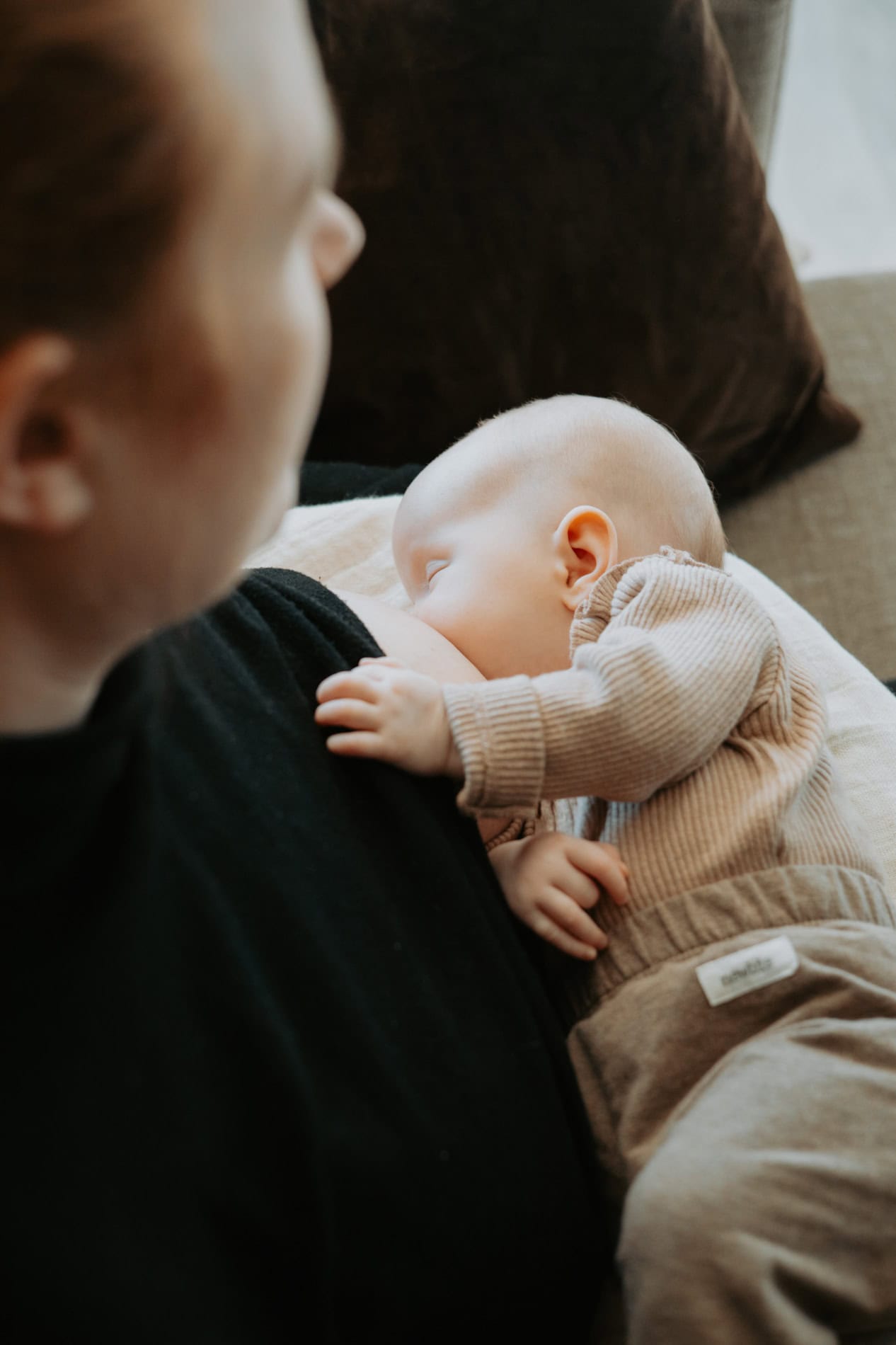 Bildet viser en mor som ammer sitt spedbarn hjemme. Fotograf Heidi Henriksen fanger intime familiebi.