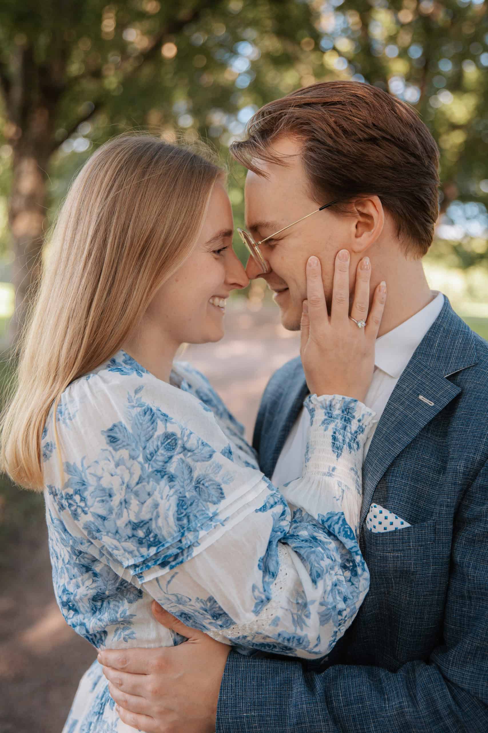 Nærbilde av et lykkelig par som smiler og holder hverandre i en park i Oslo.