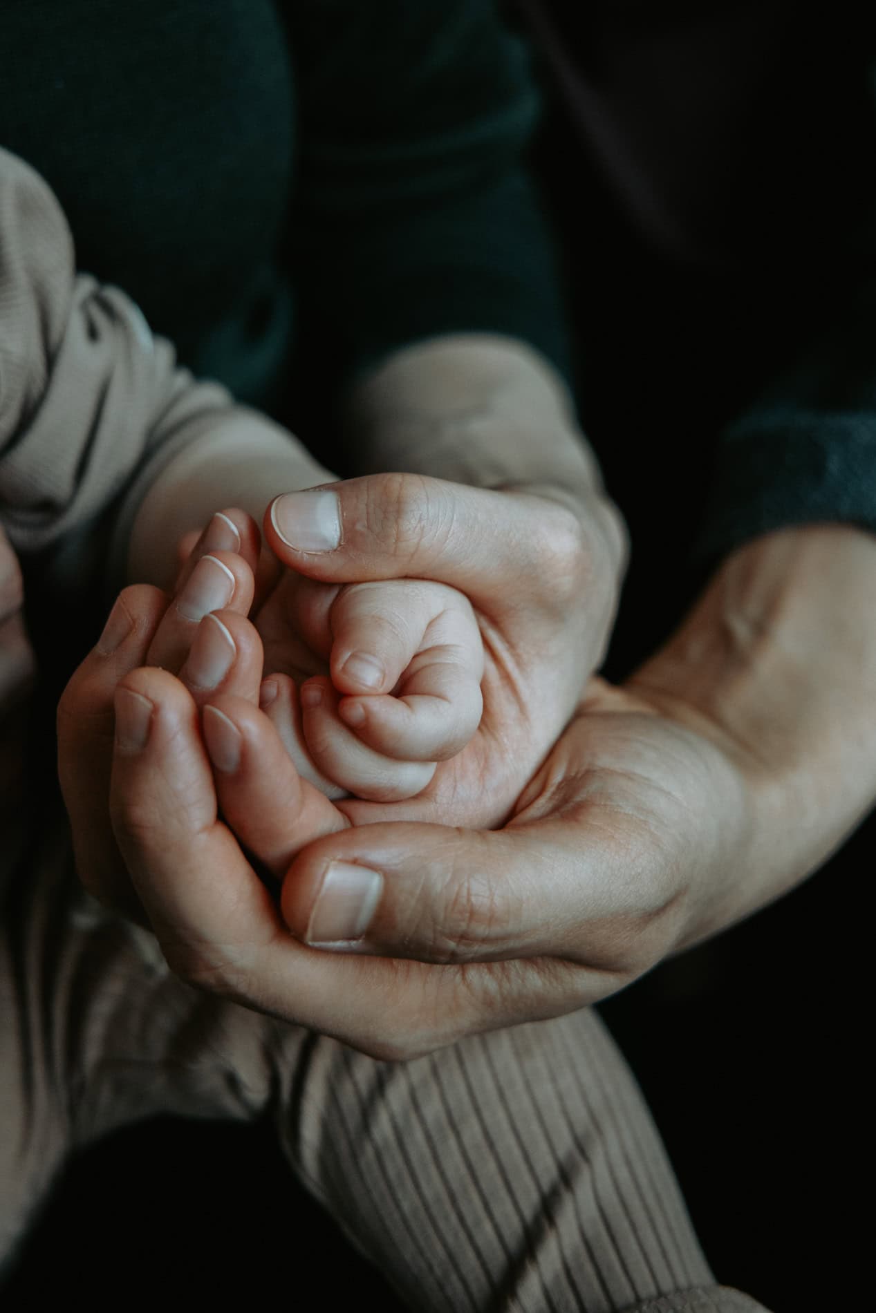 Nærbilde av en voksen og et barns hender som holder hverandre, perfekt for familiefotografering i Os.