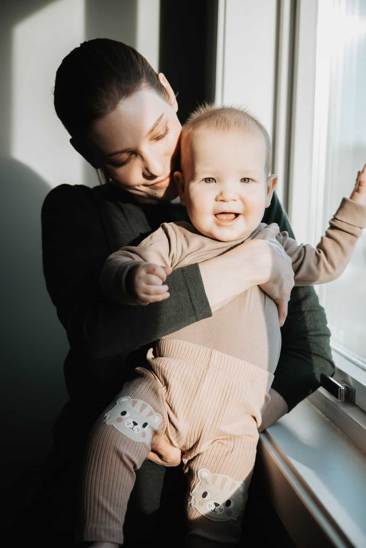 Familiefotografi med mor og barn ved vinduet i Oslo. Profesjonell fotograf Heidi Henriksen.
